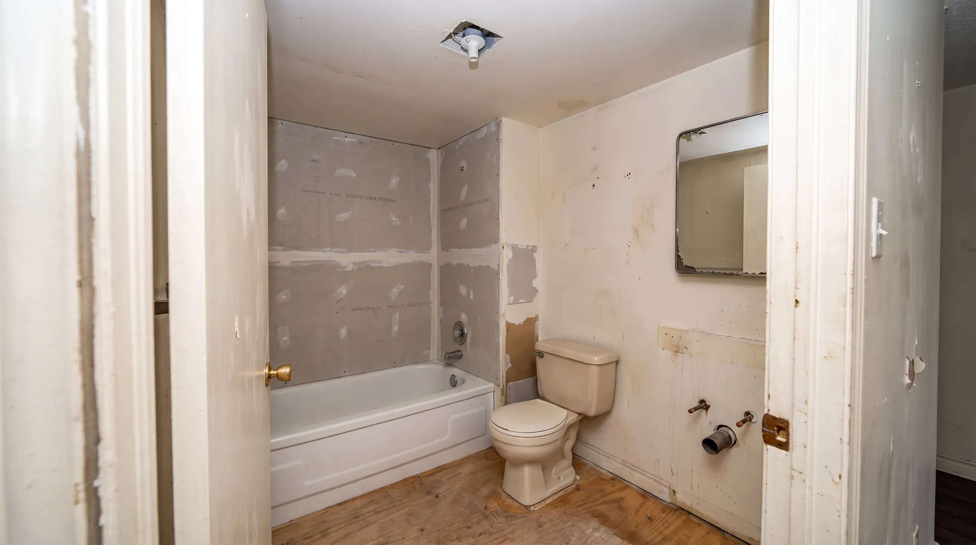 Illustration of the same bathroom gutted to cement backer board and subfloor